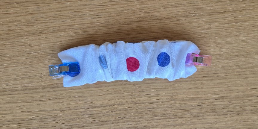 Threading elastic through the fabric casing using a safety pin.