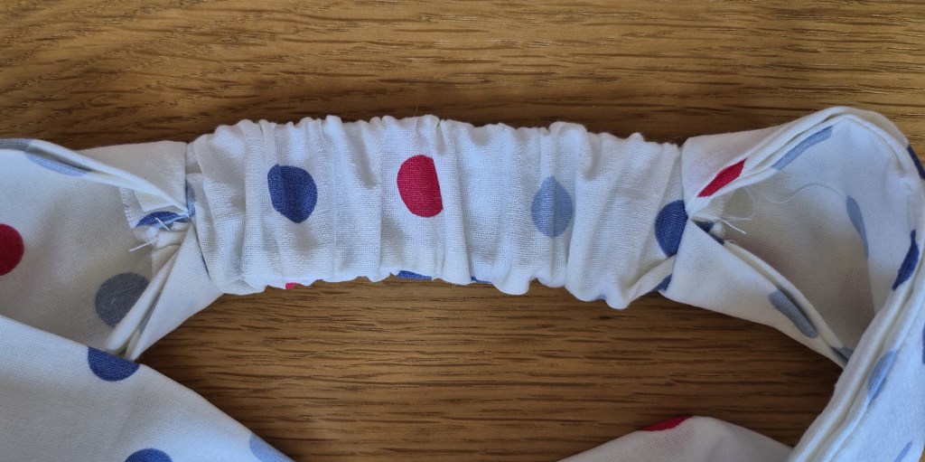 Close-up of sewing a twisted headband from a fat quarter, beginner-friendly project.